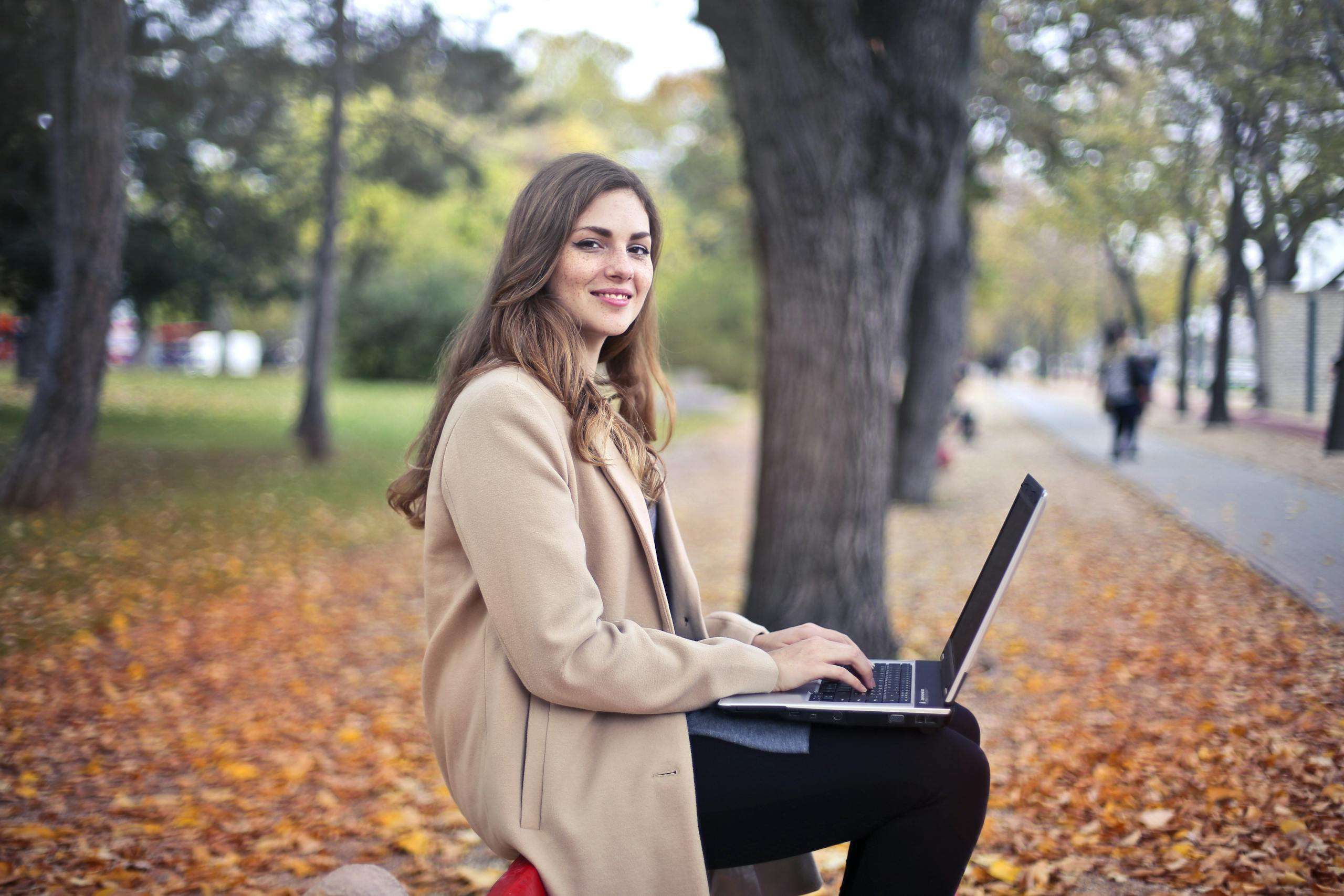 Joyful confident woman using netbook in park In this article, we'll explore common SEO mistakes that mom bloggers often make and provide practical tips to avoid them.